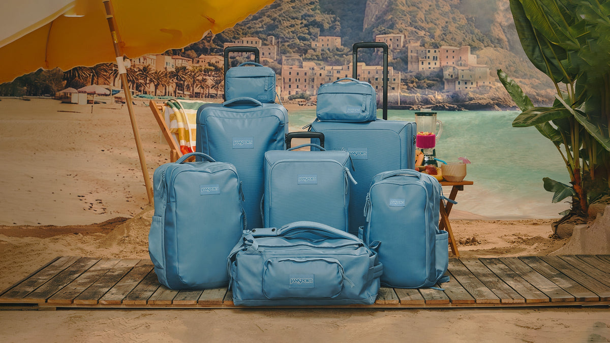 Blue JanSport travel bags and luggage by the beach